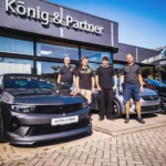 2 Kfz-Mechatroniker-Azubis mit Serviceleiter und Werkstattmeister vor dem Autohaus König & Partner