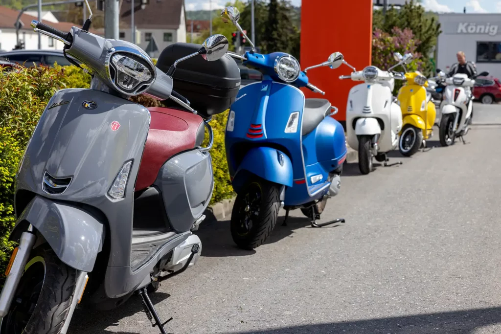 Reihe von parkenden Motorrollern bei der Neueröffnung von Rollerino by König & Partner