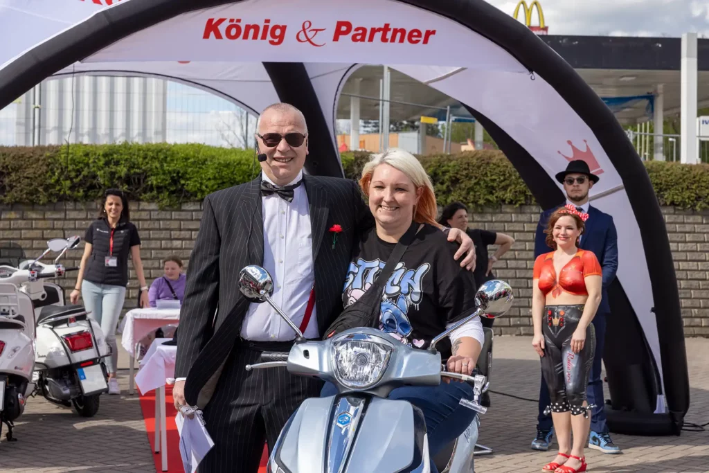 Don Silvio und Sandra Wedel mit Hauptgewinn Motorroller lächeln in Kamera